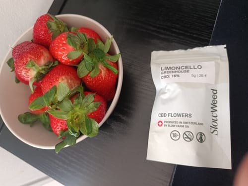 Ciotola di fragole accanto alla busta Slow Weed Limoncello Greenhouse